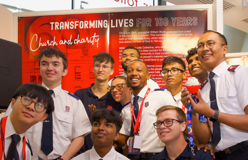 A group of the international Children and Young People Advisory group in front of the exhibition 'Transforming lives for 160 years'