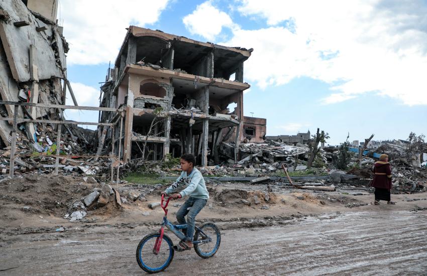 Amid the massive destruction in Jabaliya camp, a child rides his bicycle through the camp's streets.