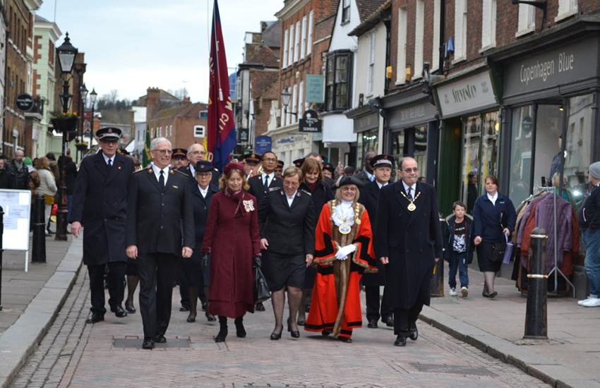 A group in Salvation Army uniform march down the high street alongside the mayor