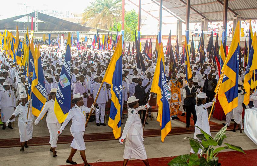 Salvationists march carrying flags