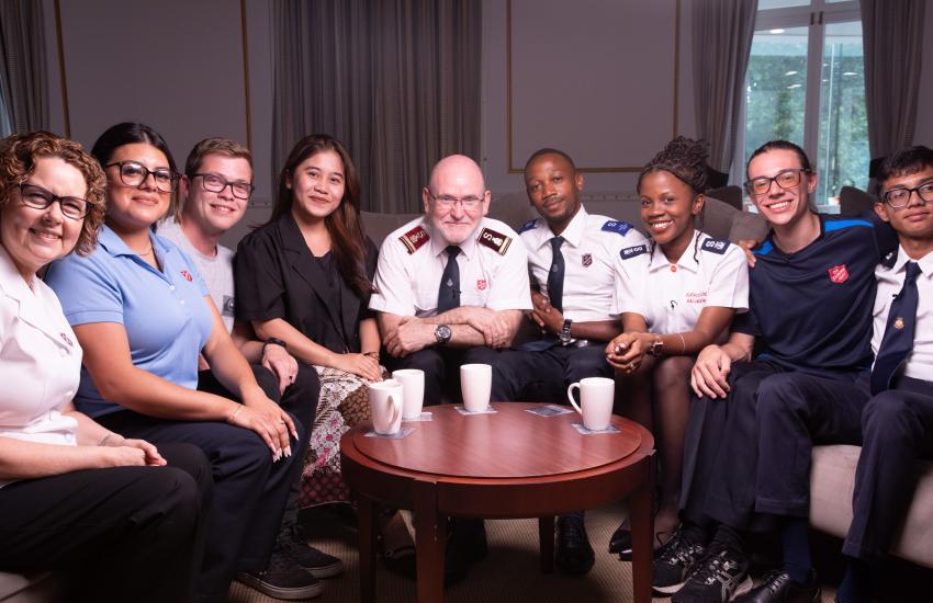 The international leaders sit around a coffee table with young Salvation Army members
