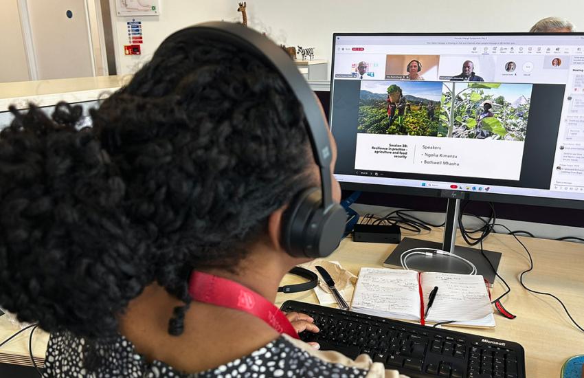 A woman joins the online symposium at her computer