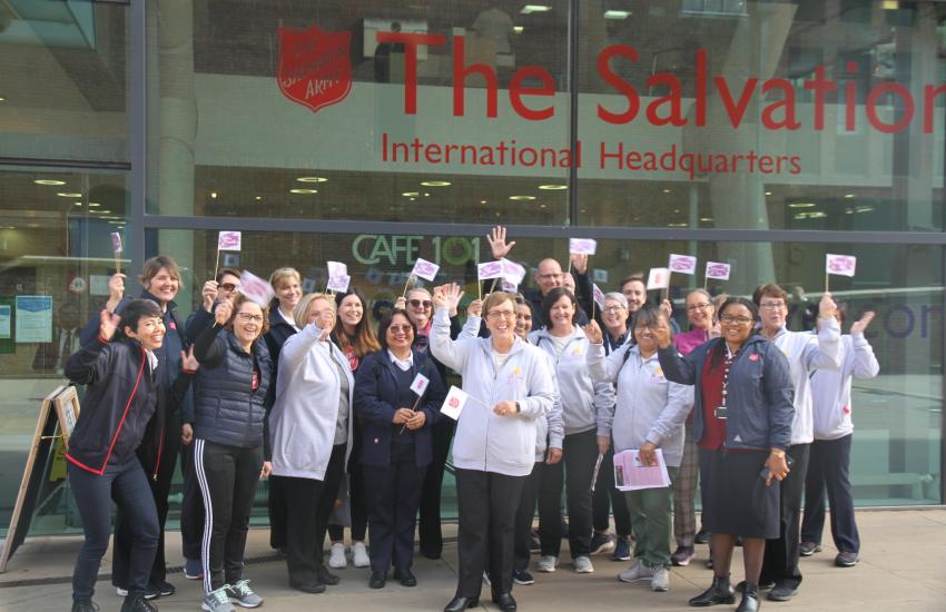 A group of women wave flags outside the IHQ building