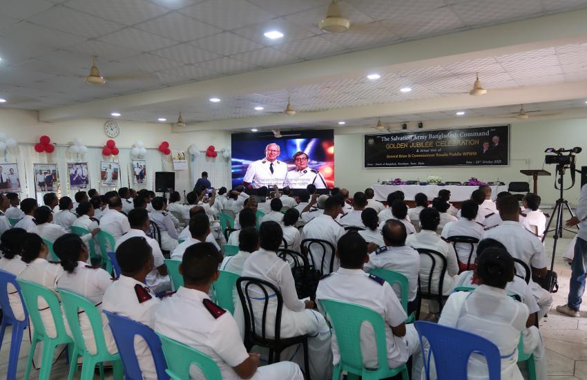 A congregation watch the international leaders on screen