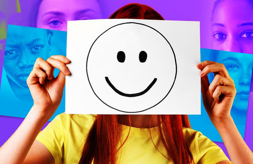Young person holding up a smiley face