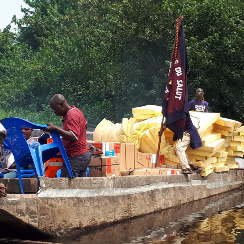 A wooden boat with a Salvation Army flag brings emergency supplies