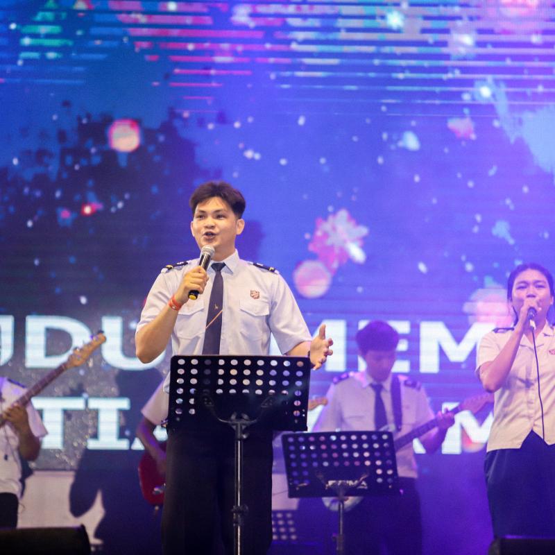 Young people in Salvation Army uniform sing into microphones