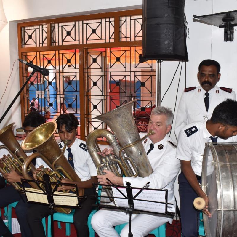 The Chief of the Staff plays the tuba alongside members of the corps playing brass instruments and a drum