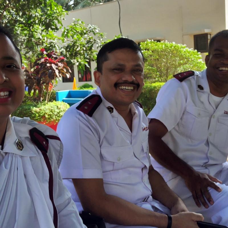 A woman and two men in Salvation Army uniform smile at the camera