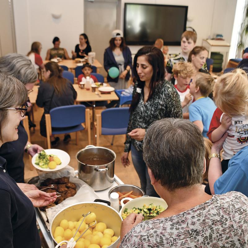 People gather around as food is served