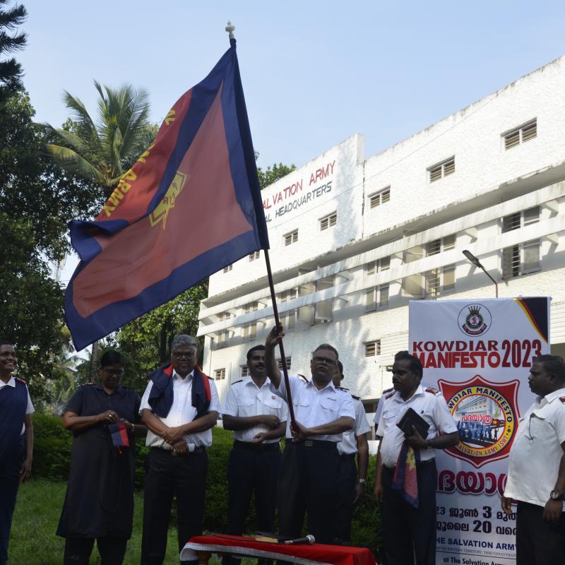 A group of people in Salvation Army uniform holding an Army flag