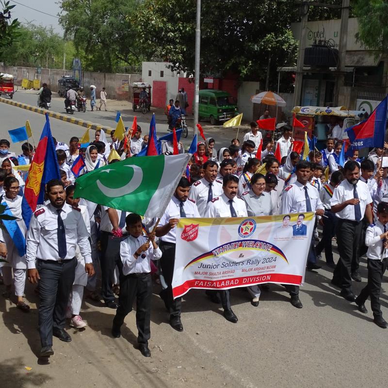 Salvationists march down the street carrying flags