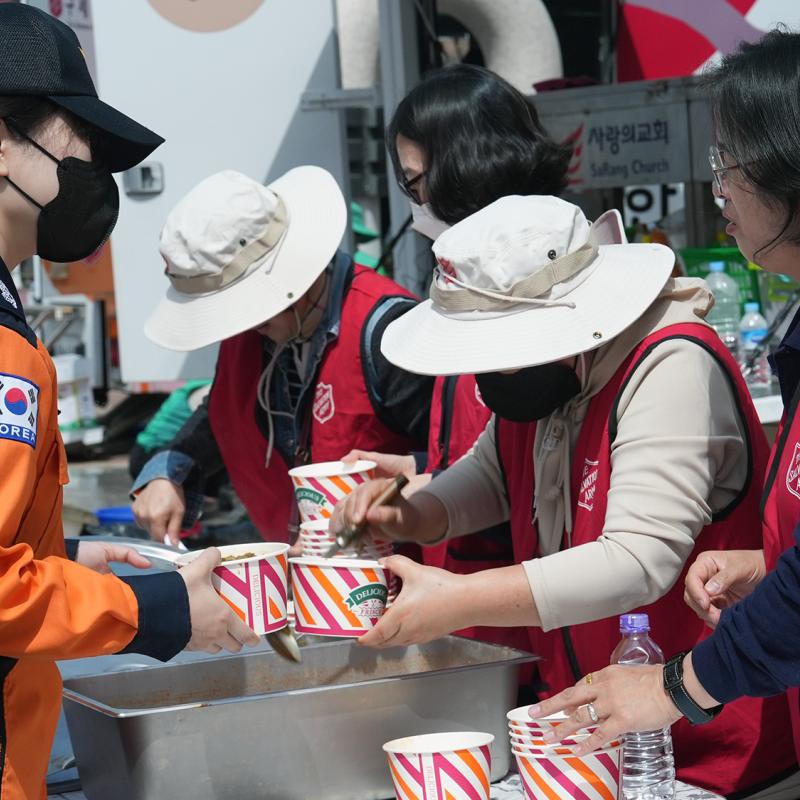 People in Salvation Army jackets hand out food