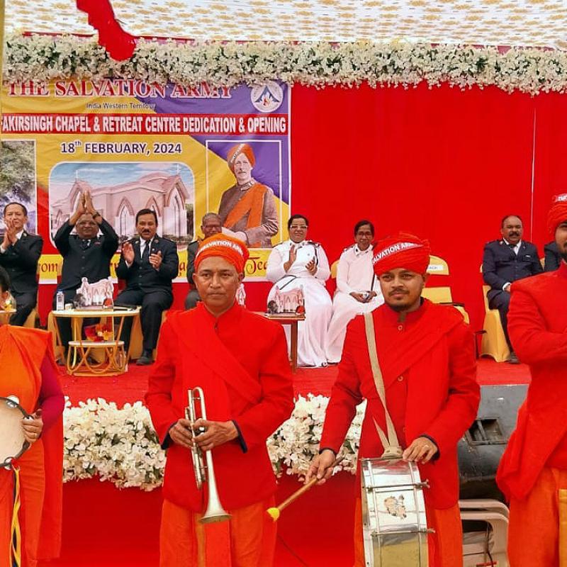 A group wearing red hold a timbrel, a trumpet, a drum and a Salvation Army flag