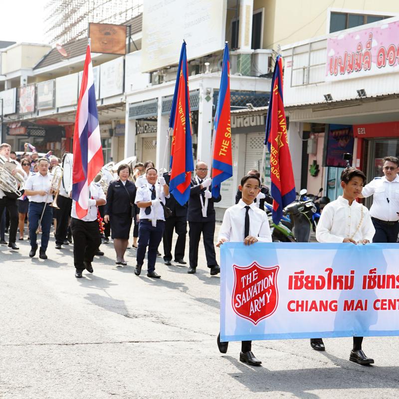 Salvationists march down the street with flags