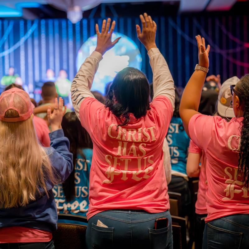 Young people raise their hands in worship