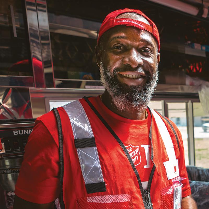 A Salvation Army emergency response worker holds a boxed meal ready to distribute