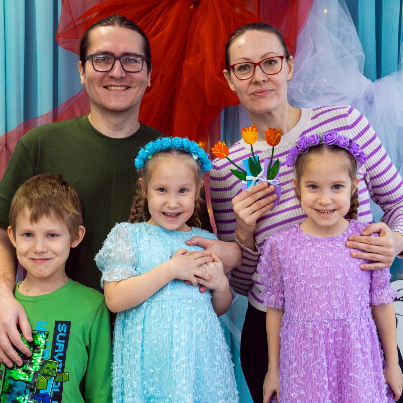 A family of five smile at the camera