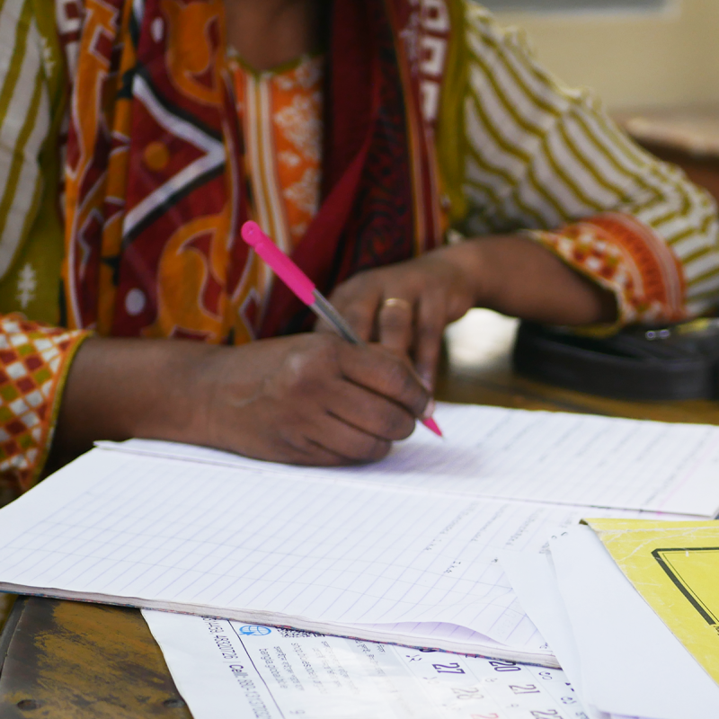 Detail of a woman writing in in a notebook