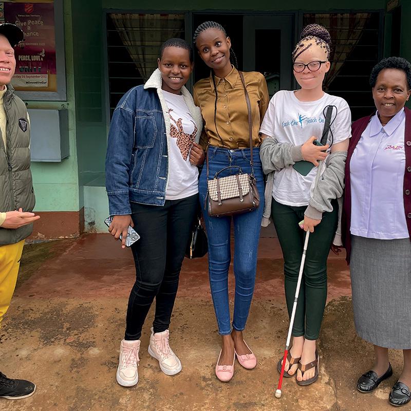 A group of high school students, one holding a mobility cane