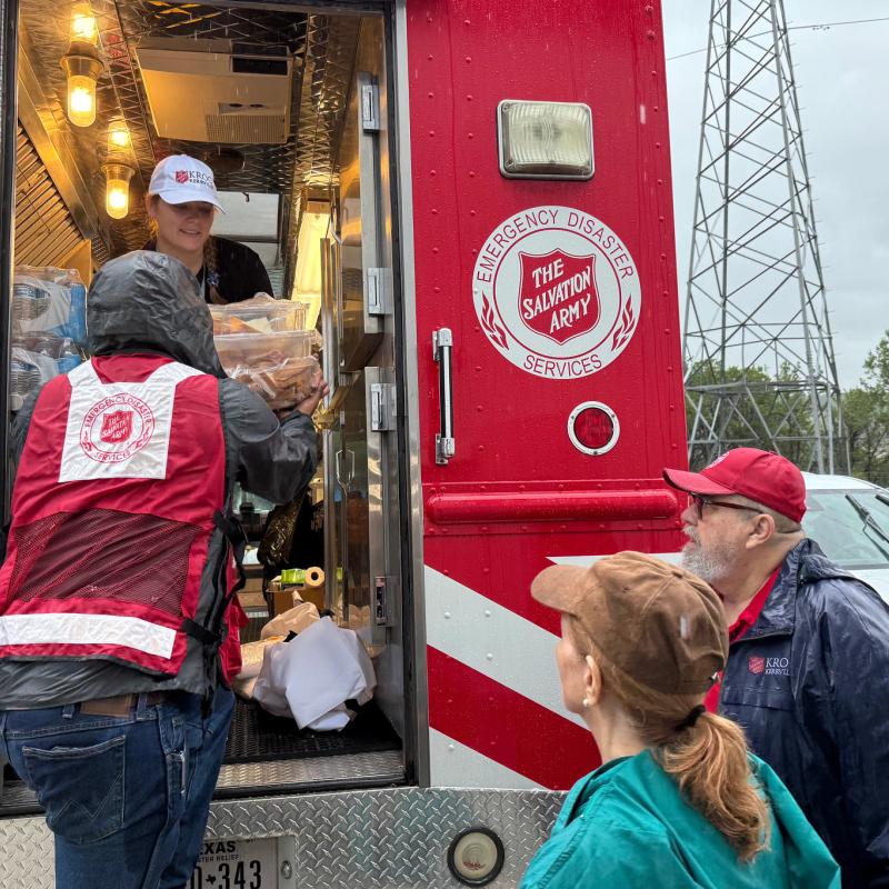 Volunteers unload supplies from a Salvation Army emergency vehicle