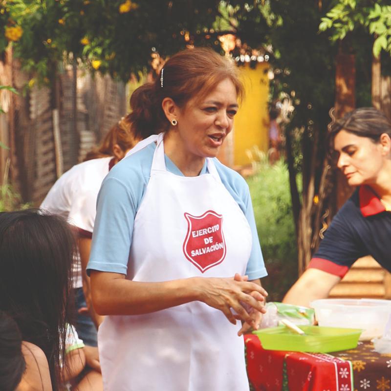A woman in a Salvation Army apron leads a workshop