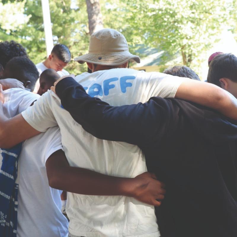 A group of young people with their arms around each other