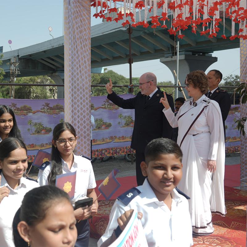 Young people in India salute as they march past the international leaders