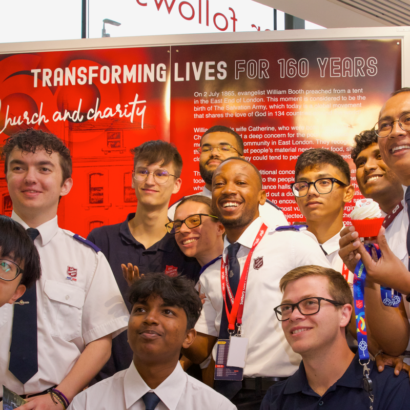 A group of young Salvationists in front of the exhibition 'Transforming lives for 160 years'