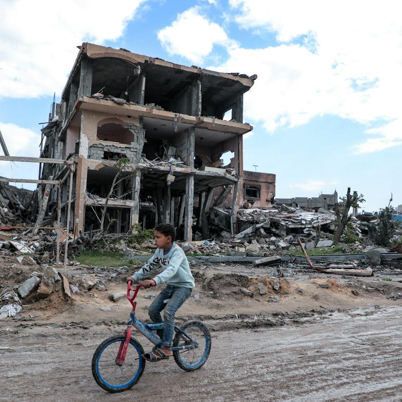 Amid the massive destruction in Jabaliya camp, a child rides his bicycle through the camp's streets.