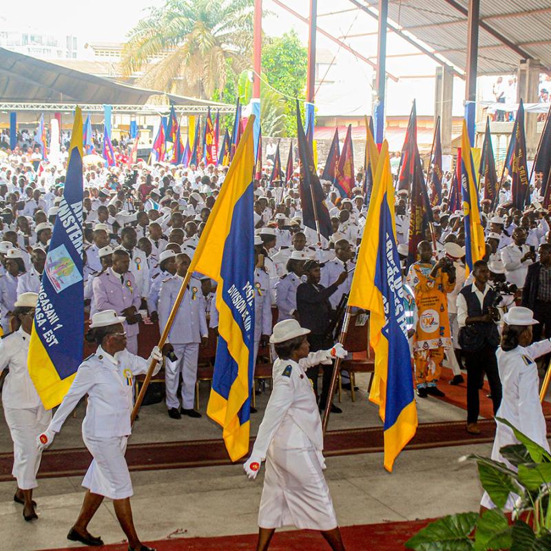 Salvationists march carrying flags