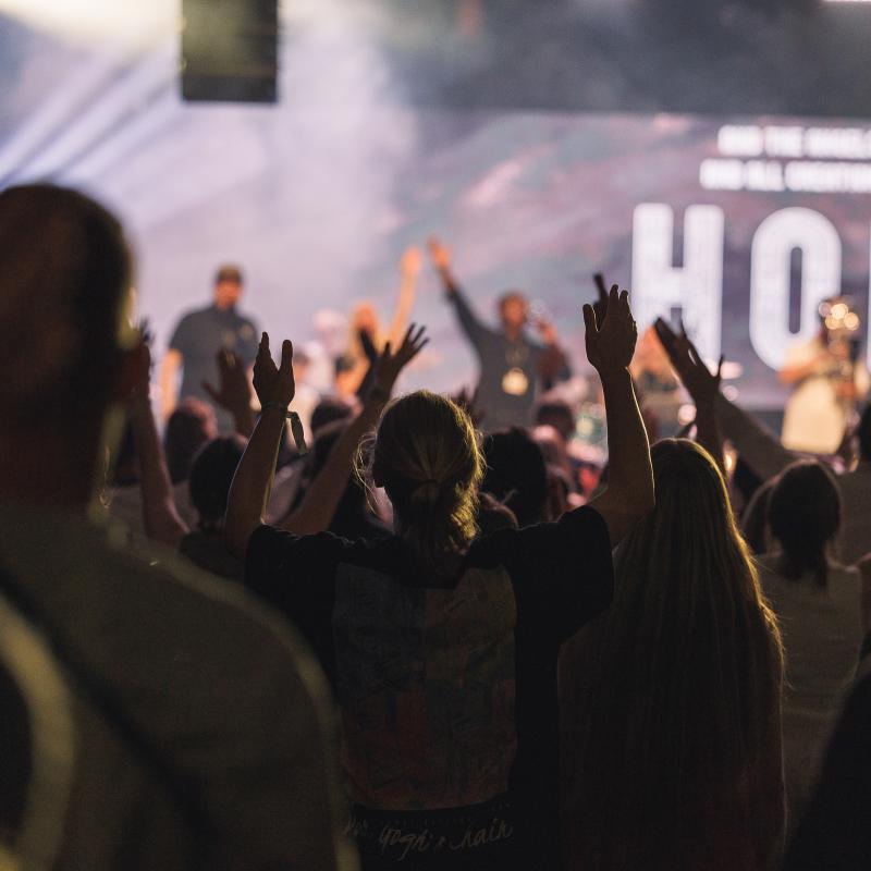 Young people raise their hands in worship