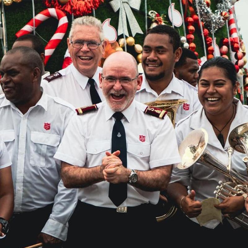 The General laughs with Salvation Army band members