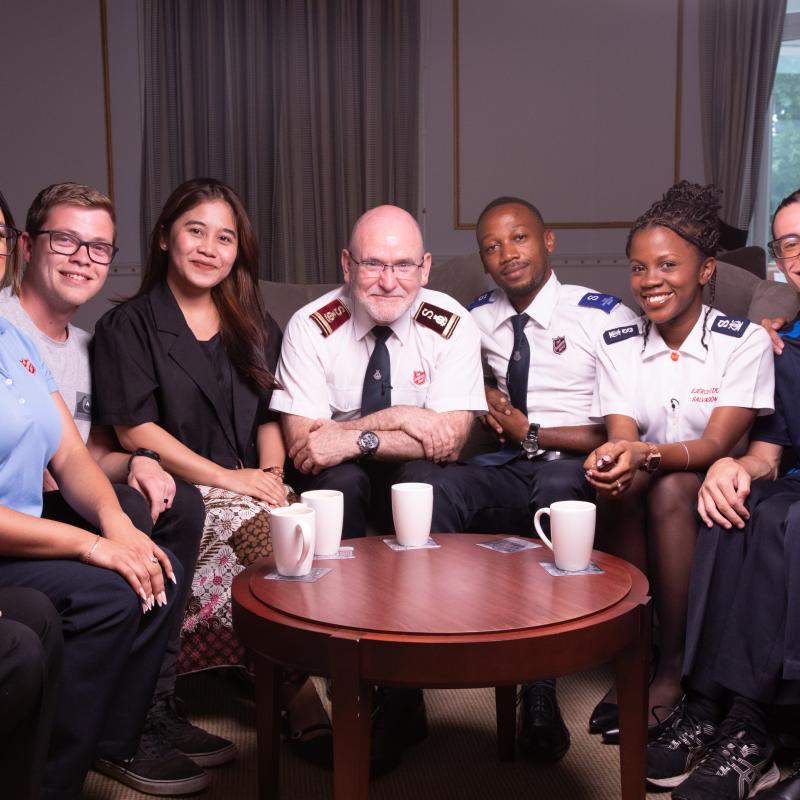 The international leaders sit around a coffee table with young Salvation Army members
